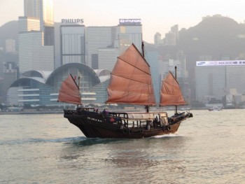 A traditional sampan still sailing along in the Hong Kong harbor. 