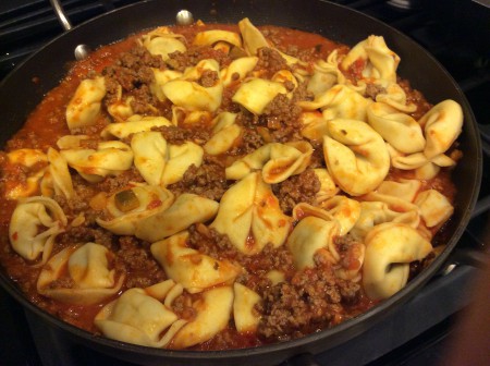sausage tortelloni pasta with meat sauce in pot