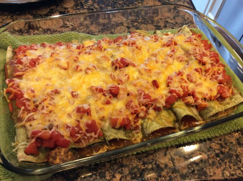 beef and spinach enchiladas in pan